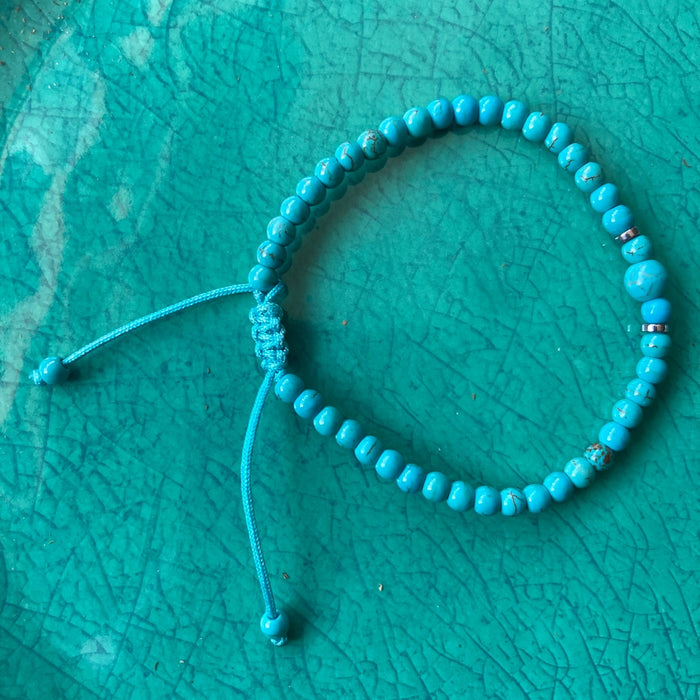 Pulsera de howlita azul con cuentas de diferentes tamaños con remates metálicos plateados, ajustable