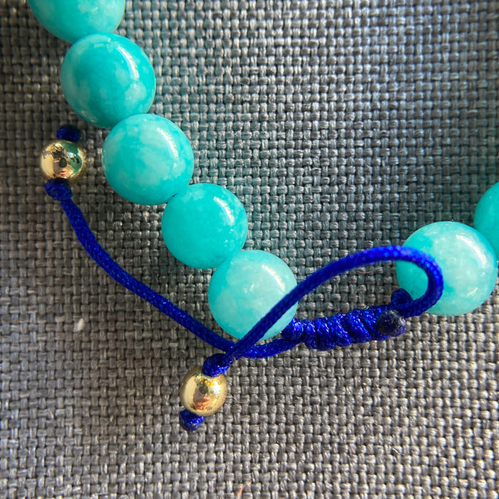 Pulsera de jade azul 8 mm con detalle de Concha y Nudo Infinito esmaltado, ajustable